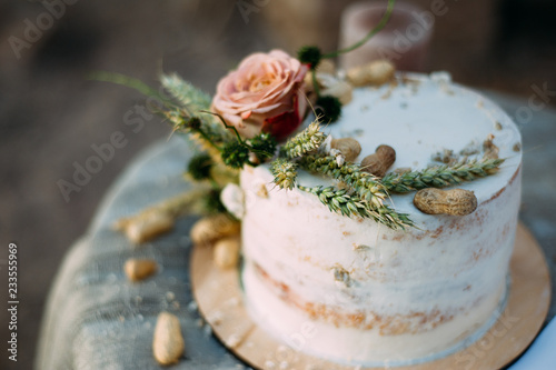  Romantic rustic pastel floral design of wedding cake on a table outdoors