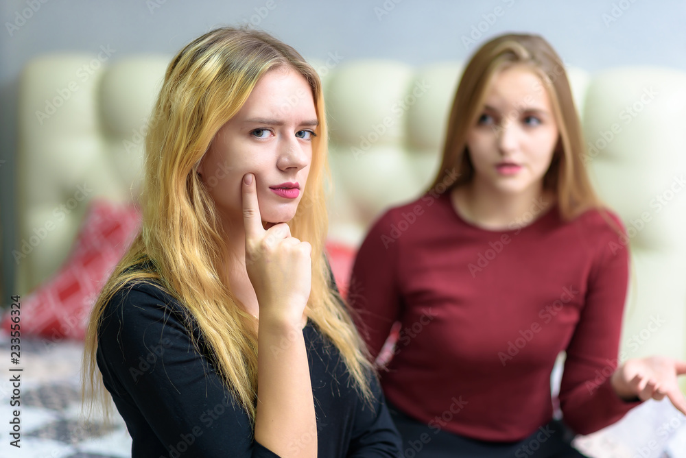 The concept a couple of beautiful young lesbian girls are talking in a room sitting on a sofa. The concept a couple of beautiful young lesbian girls are talking in a room sitting on a sofa.