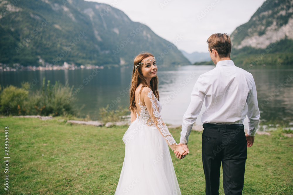 A wedding couple on the background lake and mountains in the fairy-tale town of Austria, Hallstatt.