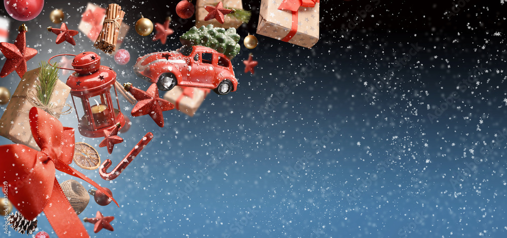 Naklejka premium Christmas background with ornaments and gift boxes covered by snowflakes on dark blue background with free space