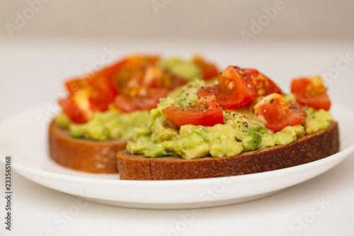 Avocado toast. Healthy toast with avocado mash and cherry tomatoes on a plate.