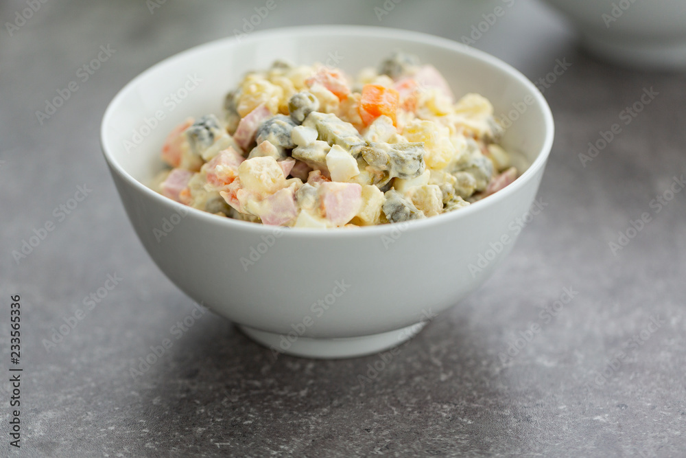 Russian salad in white bowl. National cuisine. Russian traditional salad Olivier for New Year party. Russian salad in white bowl. National cuisine. Russian traditional salad Olivier for New Year party.