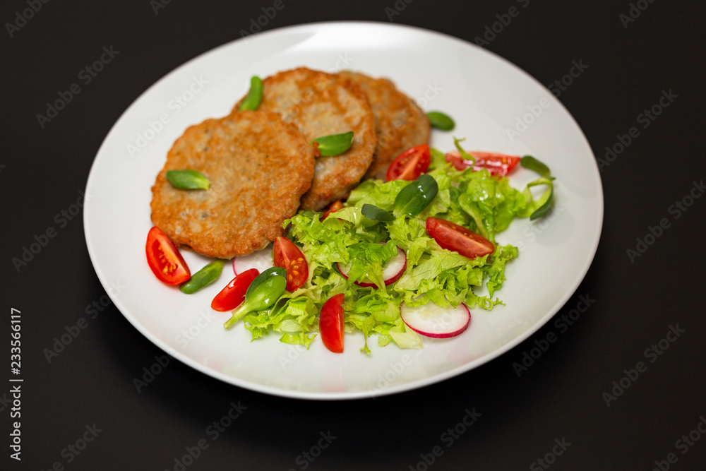 Potato pancakes with fresh mix of salad on a plate close-up. Potato pancakes with fresh mix of salad on a plate close-up.