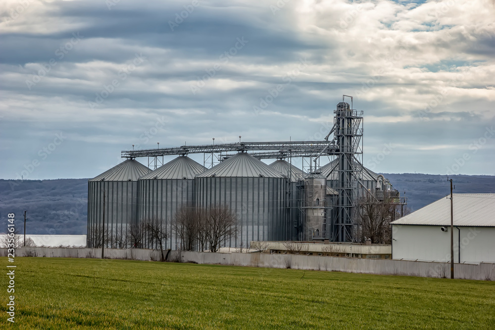 Landscape with modern agricultural Silo. Set of storage tanks cultivated agricultural crops processing plant. Landscape with modern agricultural Silo. Set of storage tanks cultivated agricultural crops processing plant.
