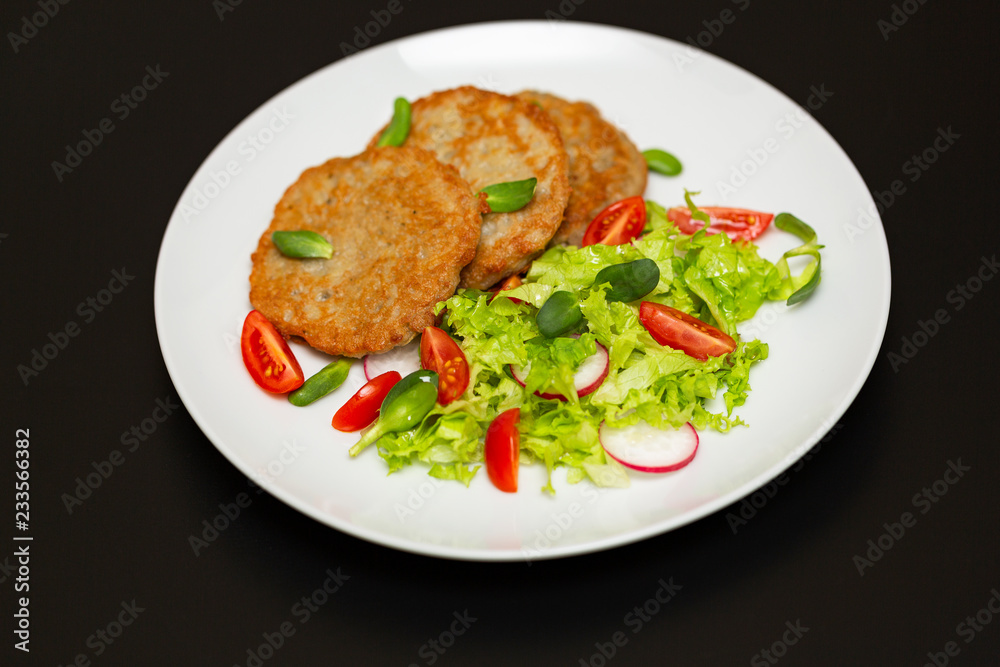 Potato pancakes with fresh mix of salad on a plate close-up. Potato pancakes with fresh mix of salad on a plate close-up.