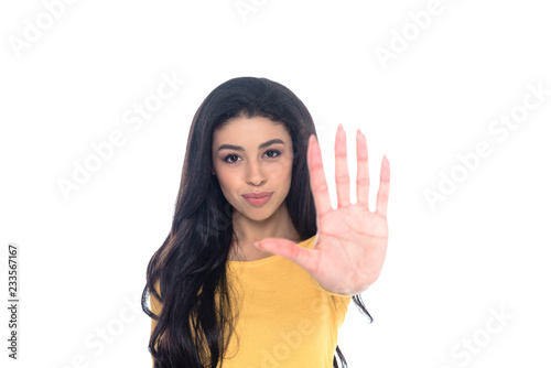 smiling african american girl showing stop sign and looking at camera isolated on white