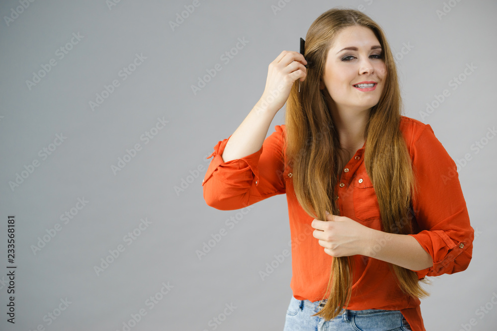 Fototapeta premium Woman combing her brown hair