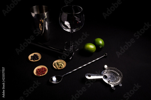 tasty and fresh gin and tonic cocktail on a black background next to your ingredients 