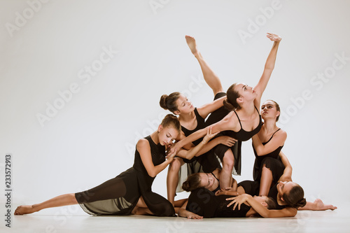 Fototapeta Grupa nowoczesnych tancerzy baletowych tańczących na szarym tle studyjnym