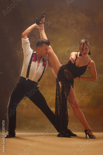 Flexible young modern couple dancing tango in studio. Fashion portrait of attractive dancing couple. Man and woman. Passion. Love. perfect skin facial and make-up. Human emotions - love and passion