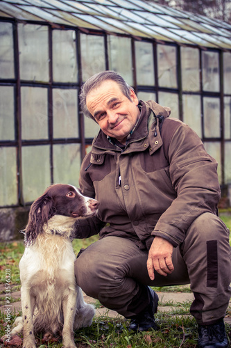 Obraz na płótnie man sitting next to a dog springer spaniel