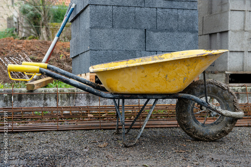 Tela yellow wheelbarrow  in construction site after use.