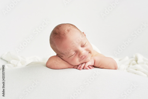 Cute newborn baby lies swaddled in a white blanket Fototapet