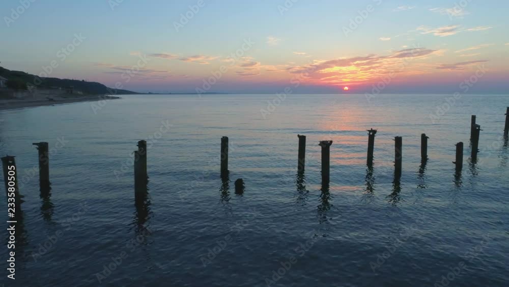 Evening on the sea of Azov. The camera slowly moves along the piles remaining from the old destroyed pier. Evening on the sea of Azov. The camera slowly moves along the piles remaining from the old destroyed pier.