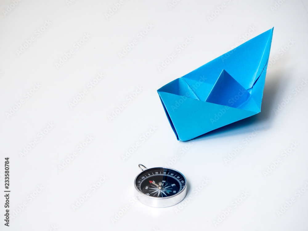Blue paper boat with compass Blue paper boat with compass
