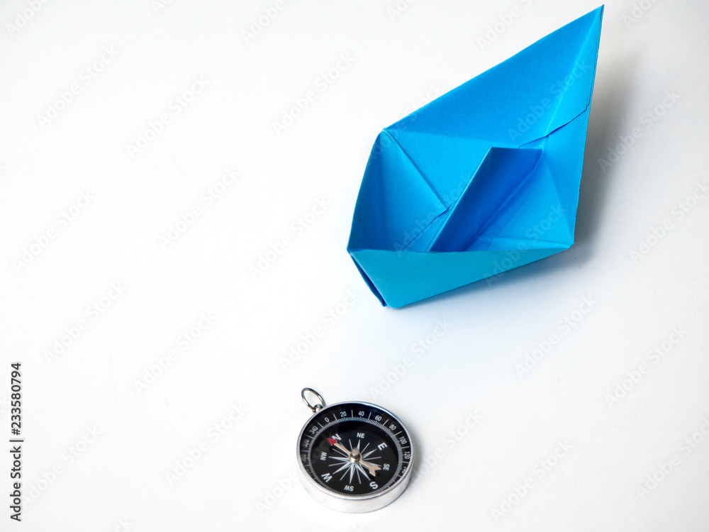 Blue paper boat with compass Blue paper boat with compass
