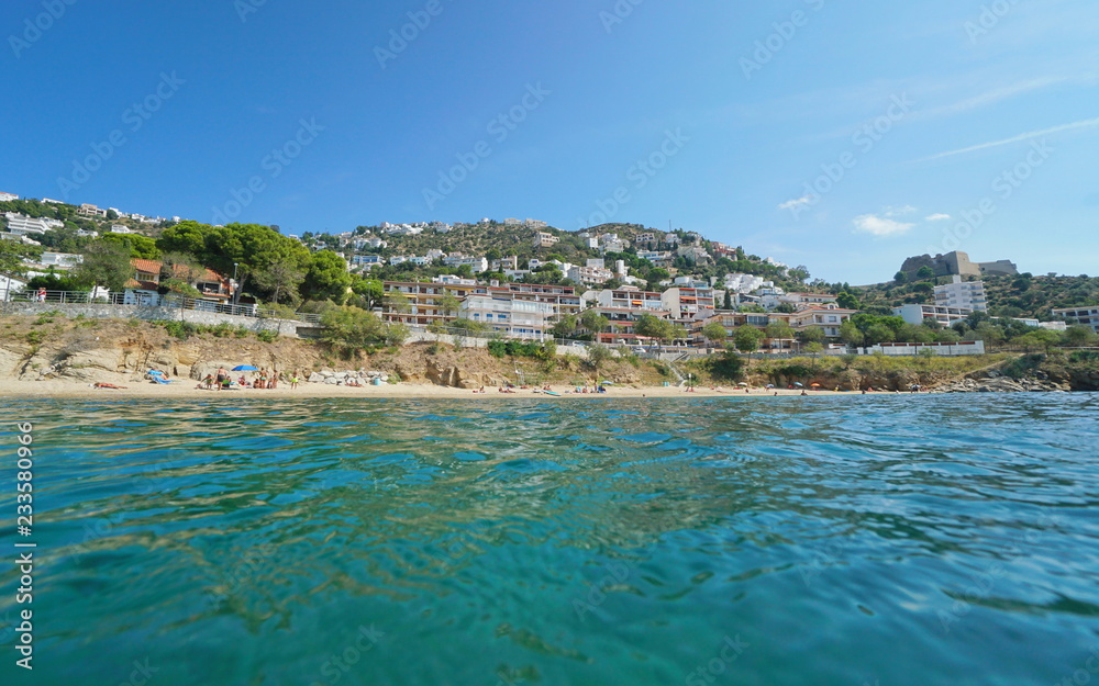 Beach with buildings in Roses seaside town, Platja dels Palangrers, seen from water surface, Spain, Costa Brava, Mediterranean sea, Catalonia, Girona, Alt Emporda
