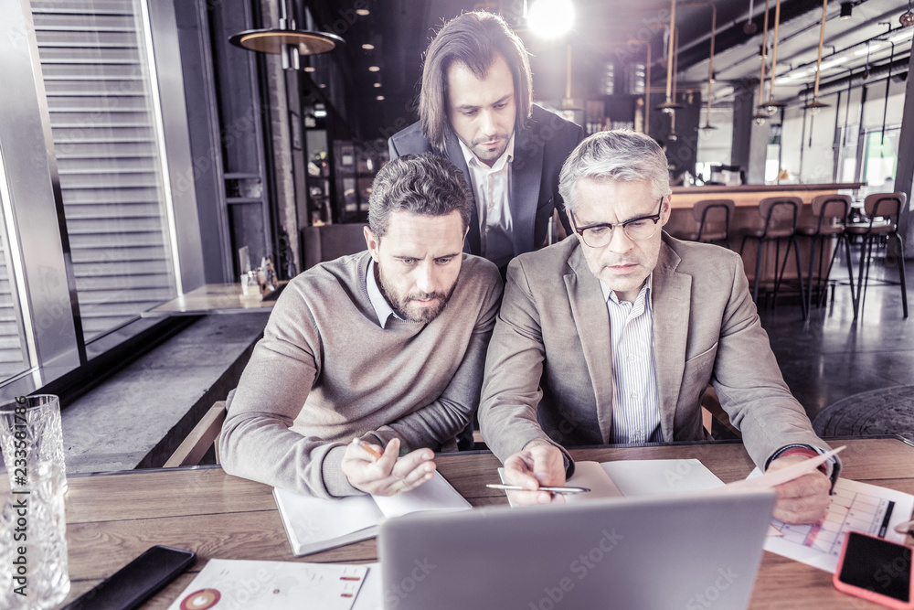 Fototapeta premium Delighted males discussing business idea during meeting