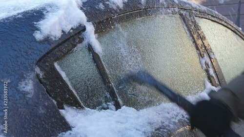 Scraping ice from car's rear window. Ice formed from an extended period of freezing rain. Winter driving in Toronto, Canada.