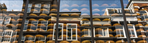 Photography Cheese shop in Amsterdam with traditional Dutch houses reflected in window