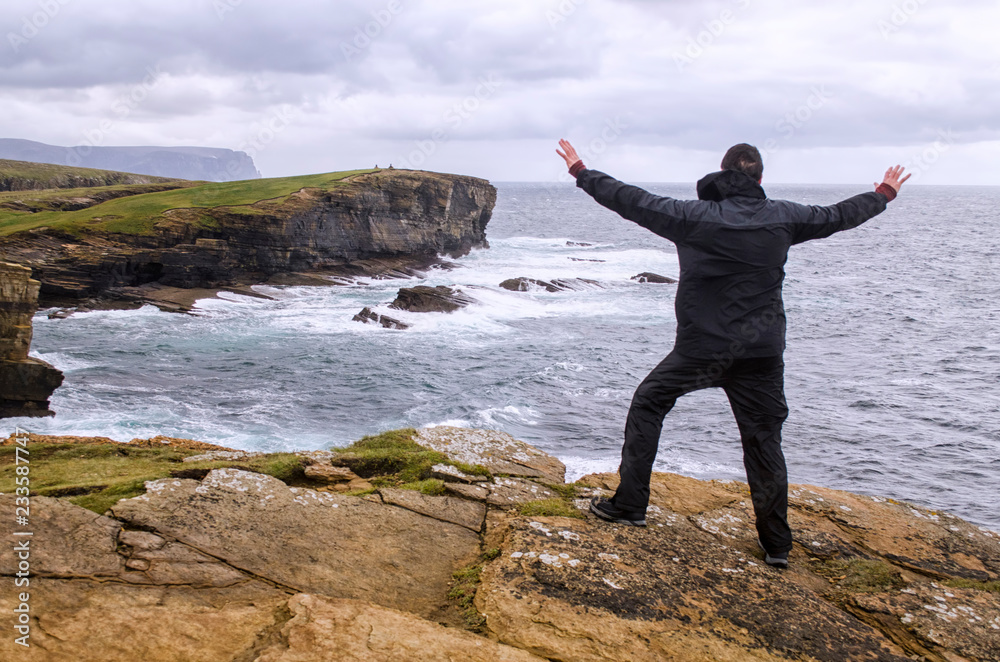 Person Standing on Coastal Cliff Edge Person Standing on Coastal Cliff Edge