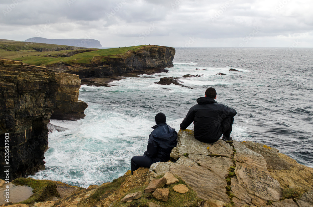 Two People Looking Over Coastal Cliffs