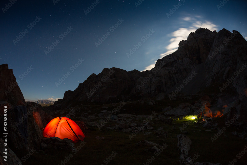 starry night sky high in the mountains and a tent
