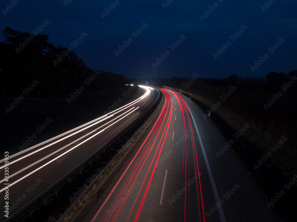 Rote und weisse Lichtspuren auf der Autobahn zur blauen Stunde, Ruecklichter und Scheinwerfer