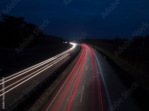 Rote und weisse Lichtspuren auf der Autobahn zur blauen Stunde, Ruecklichter und Scheinwerfer