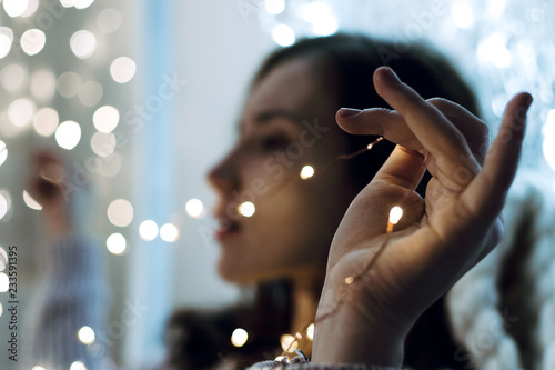 Closeup of woman's hands holding Christmas lights, shallow selective focus © lavrenkova
