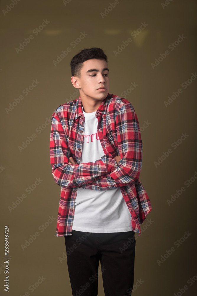 The portrait of young white boy looking aside posing isolated over green wall background The portrait of young white boy looking aside posing isolated over green wall background