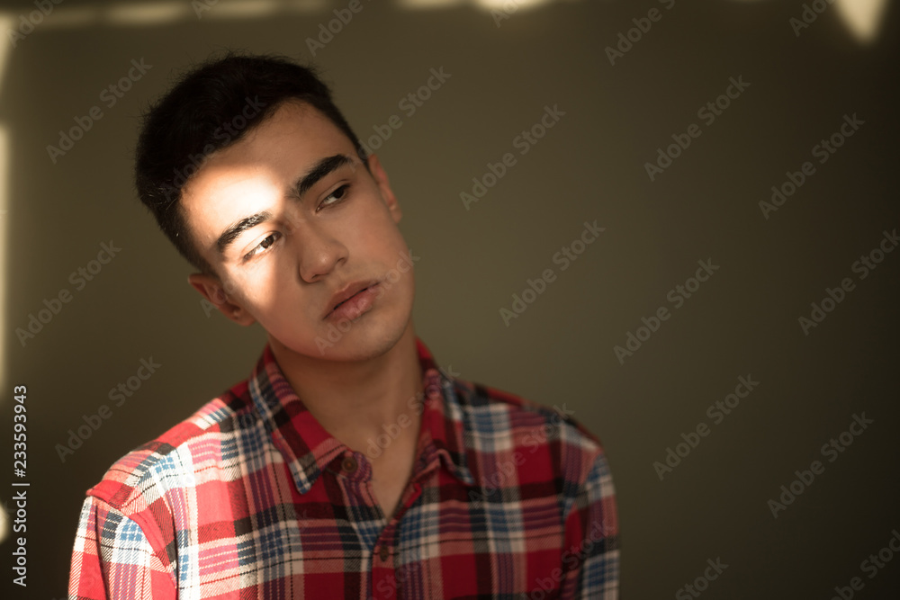 The portrait of young white boy looking aside posing isolated over green wall background The portrait of young white boy looking aside posing isolated over green wall background