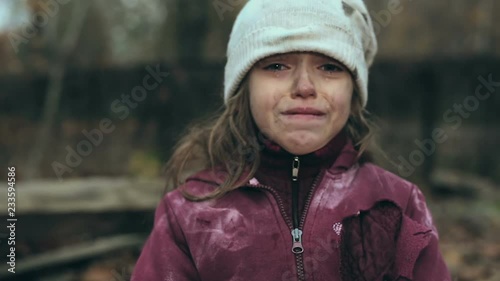 Frozen poor homeless girl holding cardboard house and looking at camera. Focus on the house and then on the face.