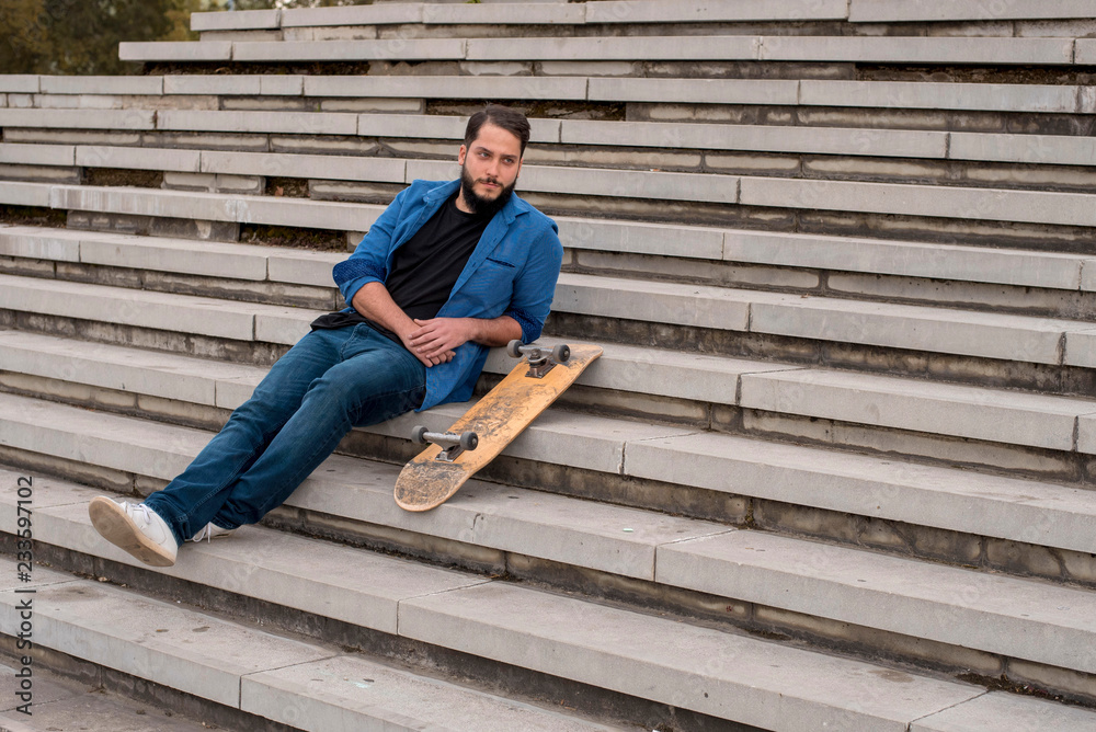 Man skateboarder relax on the concrete steps