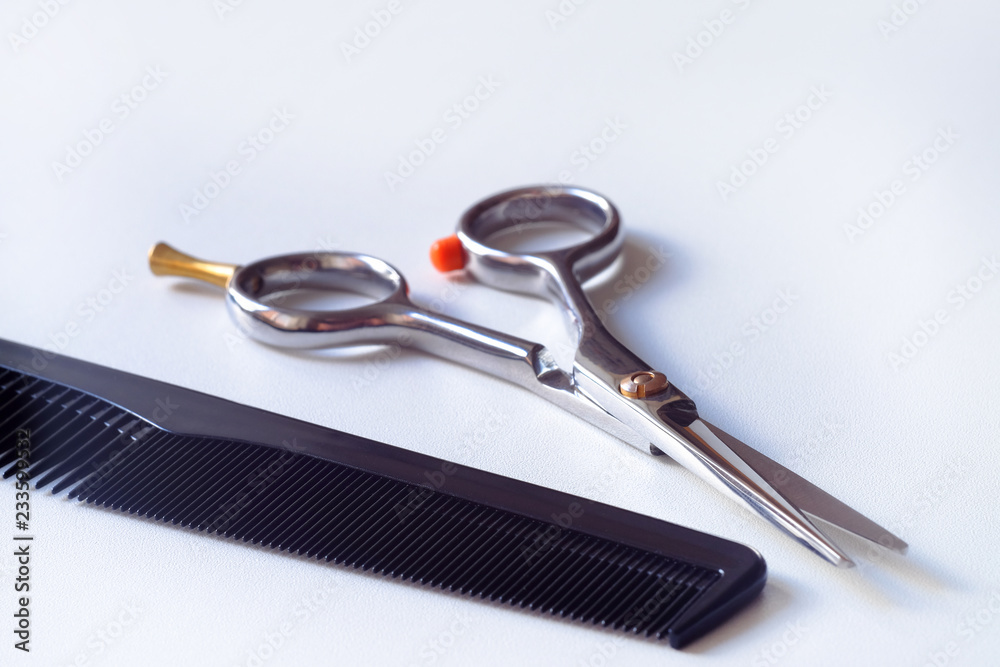 Scissors with finger rest on ring and comb isolated on white background. Scissors with finger rest on ring and comb isolated on white background.