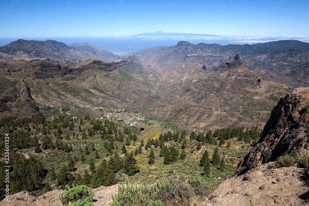 View from Roque Nublo, cultic rock of the ancient Canarians, in the Barranco del Chorrillo and the mountains in the west of Gran Canaria, behind Tenerife with Teide volcano, behind right of the cult rock Roque Bentayga, Gran Canaria, Canary Islands, Spain, Europe