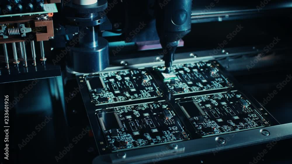 Factory Machine at Work: Printed Circuit Board Being Assembled with Automated Robotic Arm, Surface Mounted Technology Connecting Microchips to the Motherboard