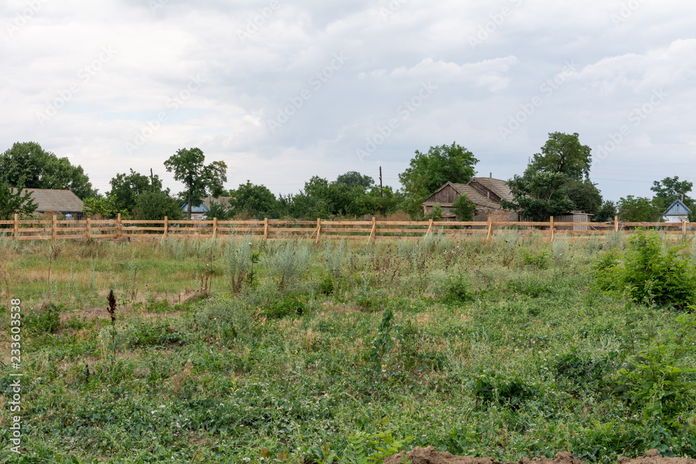 Obraz premium Ranch style fence. Rural wooden fence on green grass at farm ranch land in Shagany, Ukraina.