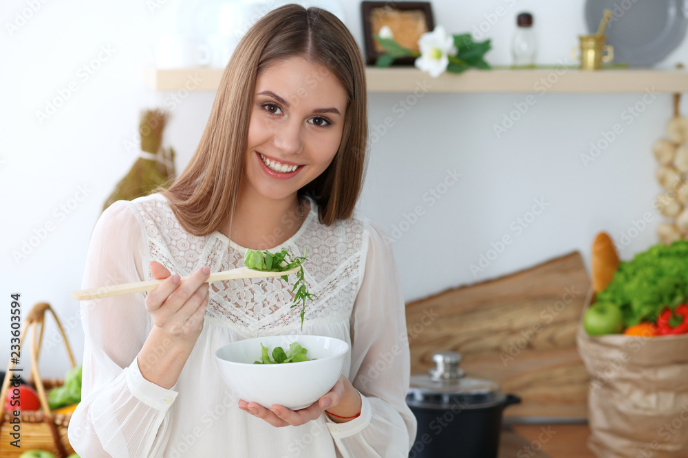 Young happy woman cooking in the kitchen. Healthy meal, lifestyle and culinary concepts. Good morning begins with fresh salad Young happy woman cooking in the kitchen. Healthy meal, lifestyle and culinary concepts. Good morning begins with fresh salad