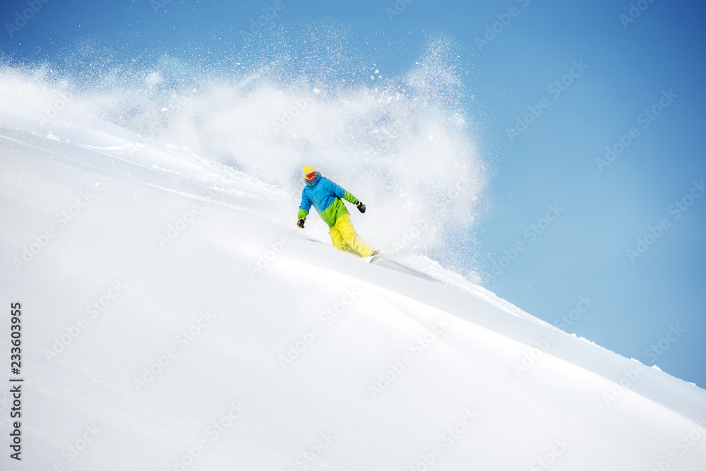Fast snowboarder at offpiste with powder