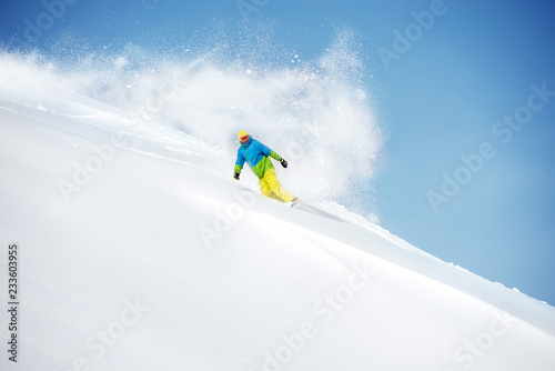 Fast snowboarder at offpiste with powder