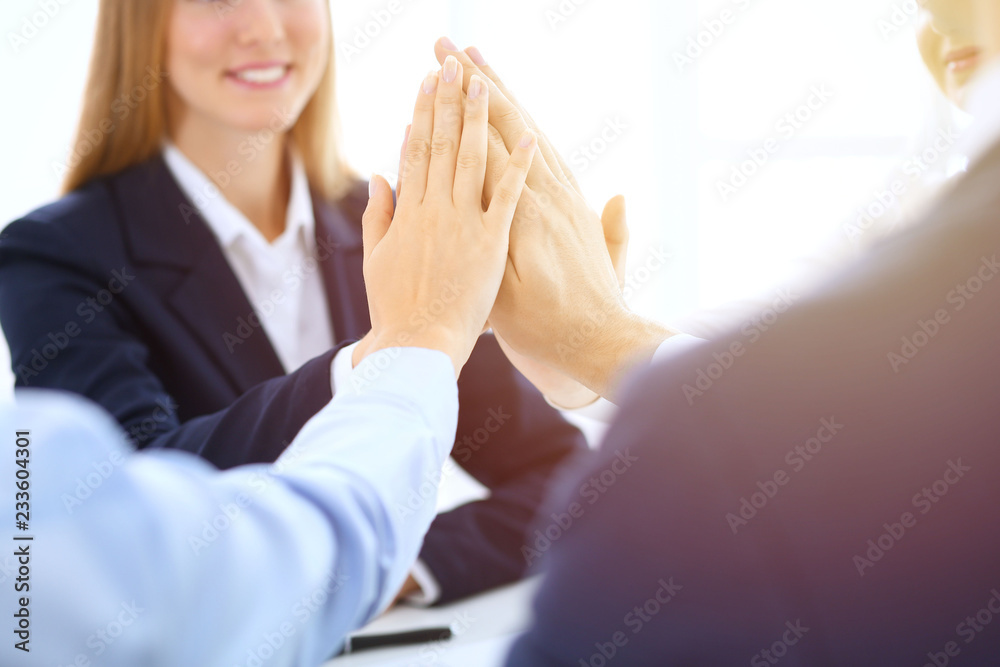 Business people happy showing teamwork and giving five showing unity and partnership. Success and friendship concepts Business people happy showing teamwork and giving five showing unity and partnership. Success and friendship concepts