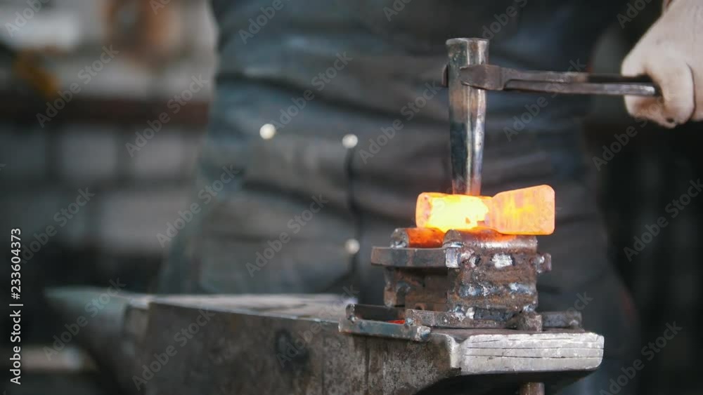 Blacksmith workroom. Making a detail with a chisel Blacksmith workroom. Making a detail with a chisel