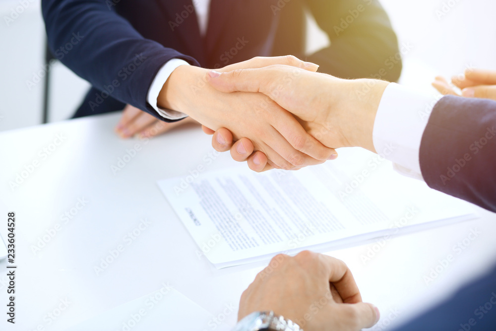 Group of business people or lawyers shaking hands finishing up a meeting , close-up. Success at negotiation and handshake concepts Group of business people or lawyers shaking hands finishing up a meeting , close-up. Success at negotiation and handshake concepts