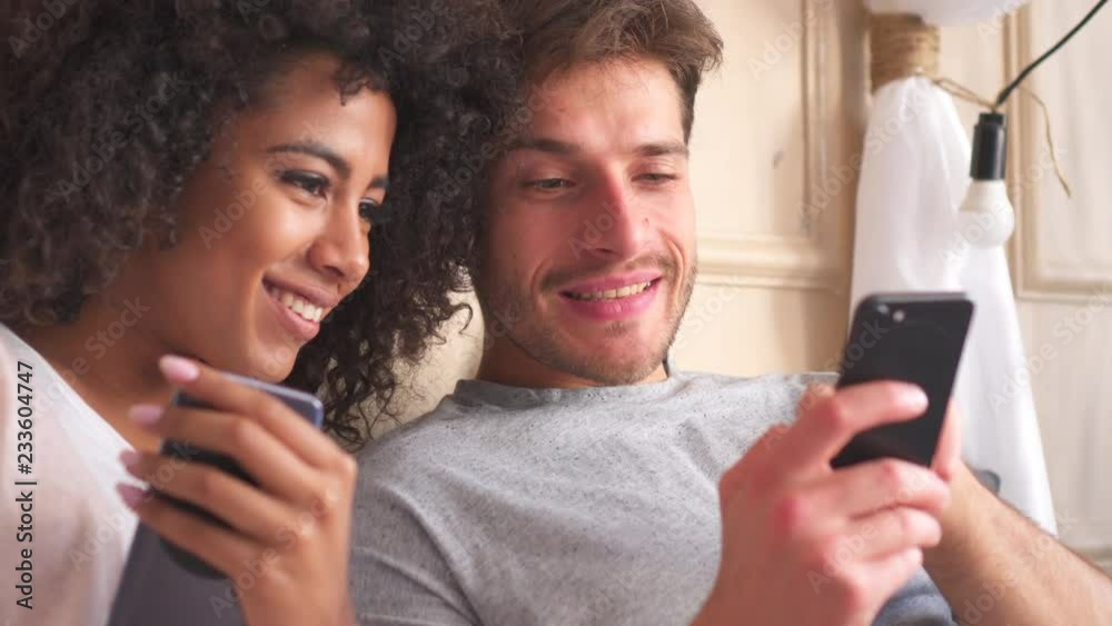Happy couple sharing mobile phone at home