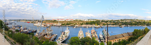 Panorama of Yuzhnaya bay in Sevastopol, Ships of the Black Sea Fleet of Russia and view to the factory and the city. © miklyxa