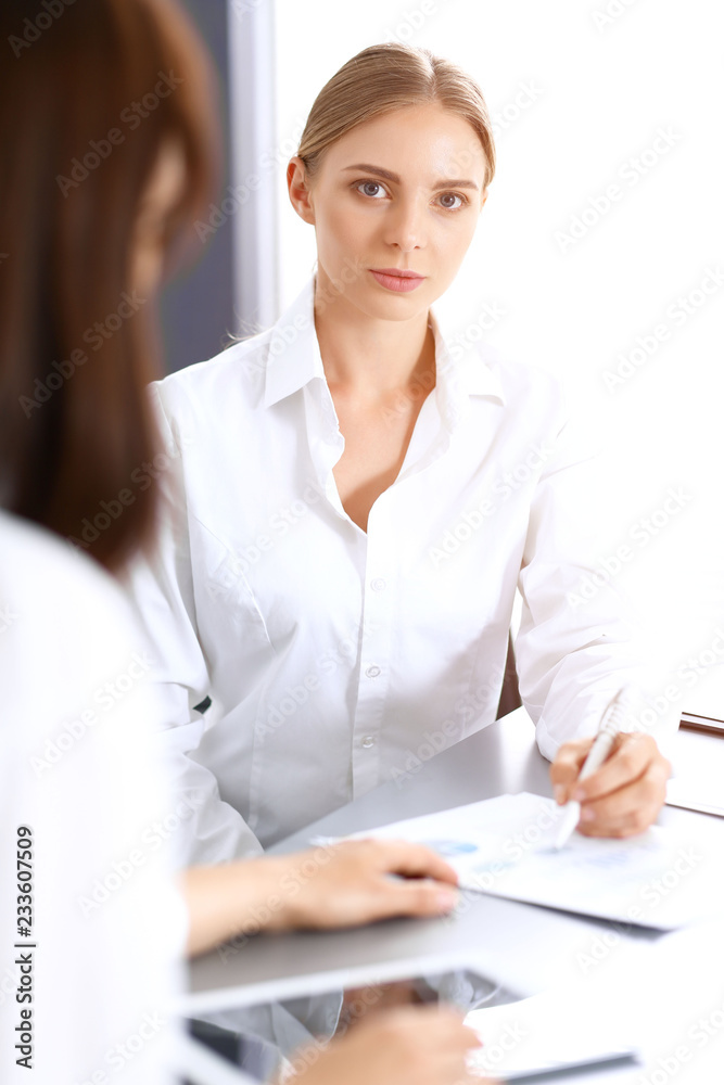 Group of business people or lawyers discussing terms of transaction in office. Colleagues working all together. Focus at blonde woman. Meeting and teamwork concept Group of business people or lawyers discussing terms of transaction in office. Colleagues working all together. Focus at blonde woman. Meeting and teamwork concept