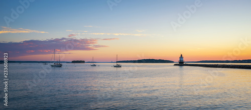Panorama sunrise of a harbor with sailboats and Spring Point Ledge Lighthouse