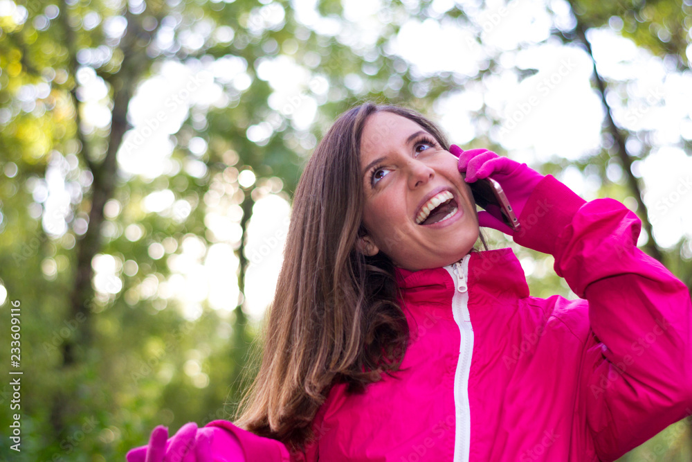 Young caucasian brunette girl talking on the phone in very happy and happy nature laughing happily in her rural vacation on the mountain Young caucasian brunette girl talking on the phone in very happy and happy nature laughing happily in her rural vacation on the mountain