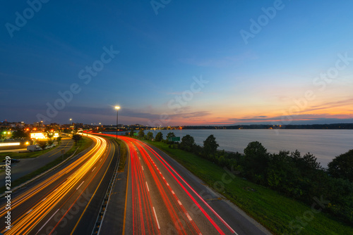 Car lights streaking along the highway at sunset 